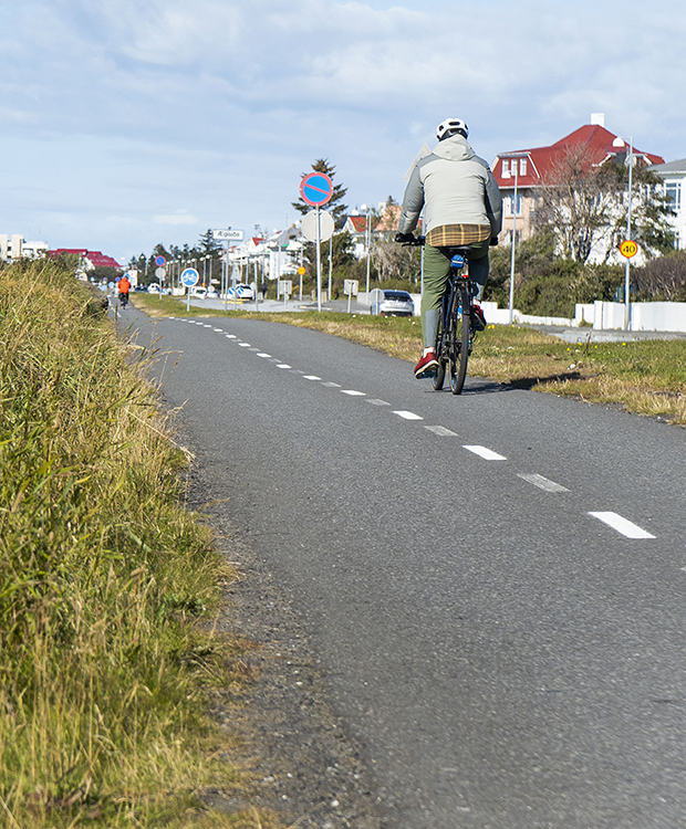 Fólk að hjóla eftir hjólastíg við Ægisíðu.