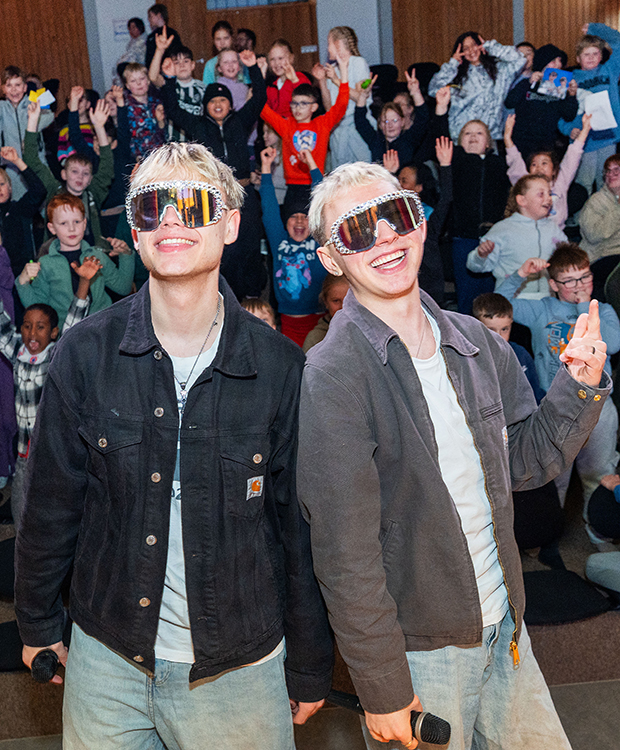 VÆB bræður á sviði með unga aðdáendur í bakgrunni.