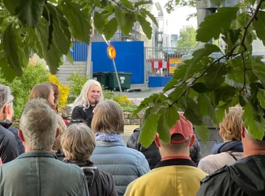 People listening to a guided talk during an evening walk.