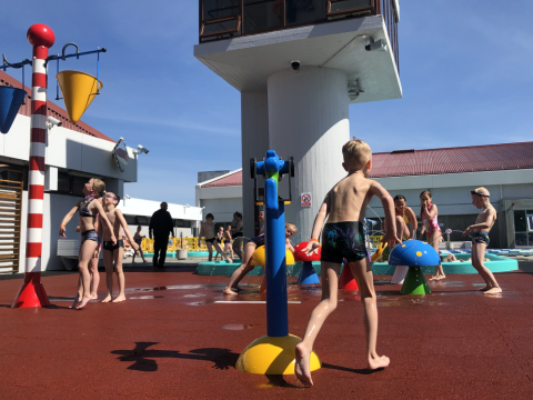 Krakkar að leik á blíðviðrisdegi á bakka Breiðholtslaugar