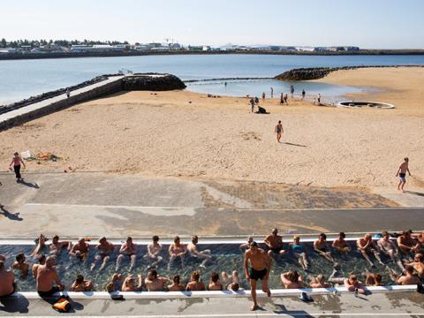 View over the hot tub, the warm beach and out to Fossvogur