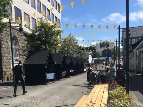 Sölubekkir, blóm og borð á sumardegi í Austurstræti.