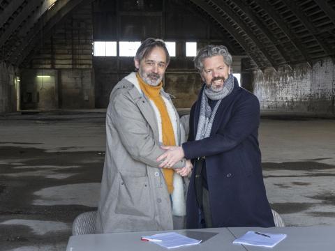 Gengið frá kaupsamningi með handabandi. Baltasar Kormákur Baltasarsson, kvikmyndaleikstjóri og eigandi RVK Studios og Dagur B. Eggertsson borgarstjóri í skemmunni sem RVK Studios hefur nú fest kaup á.