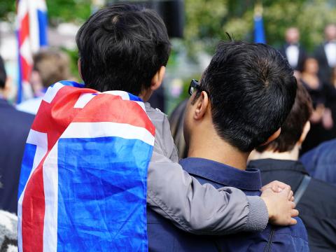 Myndin sýnir feðga en drengurinn er vafin í íslenska fánann.