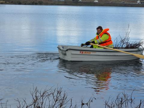 Starfsfólk garðyrkjunnar á báti á Rauðavatni að útbúa hreiðurstæði fyrir flórgoða.