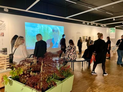 Fólk  í sýningarsal að skoða myndband um Nýja Skerjarfjörð í gamla Munch safninu í Osló.