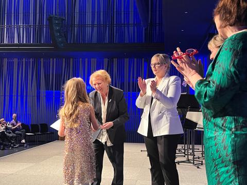 Frú Vigdís Finnbogadóttir afhendir vinningshafa verðlaun.