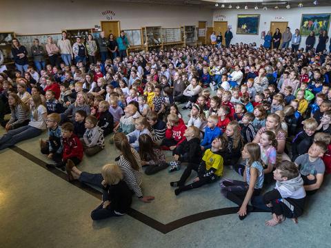Skólabörn sitjaí sal grunnskóla