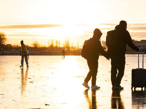 Fólk gengur yfir ísi lagða Tjörnina í Reykjavík. 