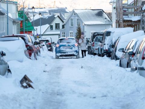 Smábíll er ekið niður götu í miðbæ Reykjavíkur í miklum snjó.