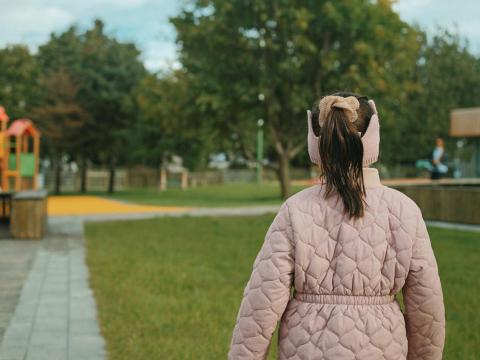 Stúlkubarn horfir yfir leikskólalóð.