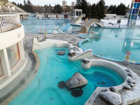 Yfirlitsmynd yfir tóma Laugardalslaug um vetur, hrím og snjór yfir öllu og lauginn kyrr, logn