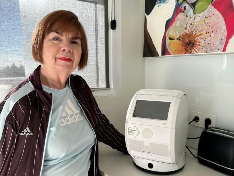 Kona stendur við lyfjaskammtarann sinn.