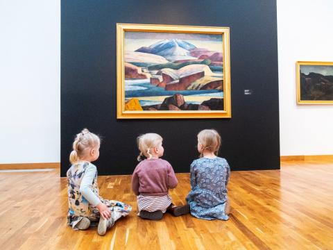 Þrjú börn sitja fyrir framan verkið Hraunteigar við Heklu eftir Jón Stefánsson.