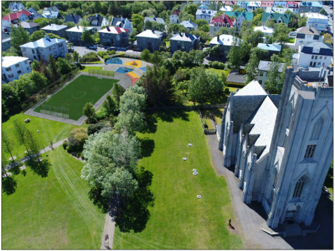 Tölvugerð mynd af Landakotstúni, með sparkvelli og leiksvæði og kirkju.