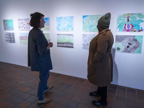 Tvær konur skoða verkin á sýningunni. 