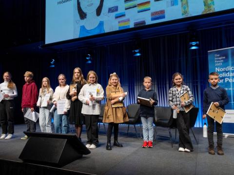 Tíu grunnskólanemar sem gerðu myndlistarverk sem valin voru til þátttöku fyrir hönd Reykjavíkur í alþjóðlegri myndlistarsamkeppni með friðarþema. Hópmynd tekin uppi á sviði í Hörpu, Norðurljósasal.