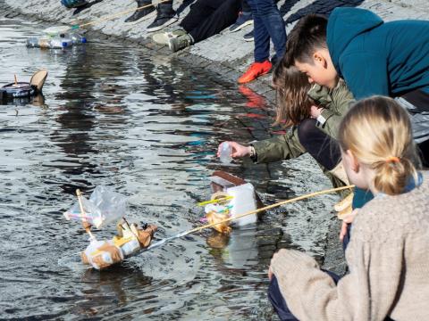 Children playing with boats at the small pond in front of City Hall