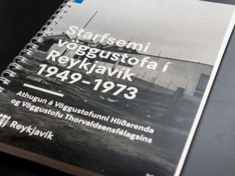Forsíða skýrslu vöggustofunefndar, mynd af skýrslunni liggjandi á borði