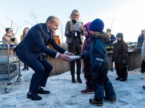 Guðni Th. Jóhannesson tekur við gjöf frá börnum í Dalsskóla, úti, í opinberri heimsókn.
