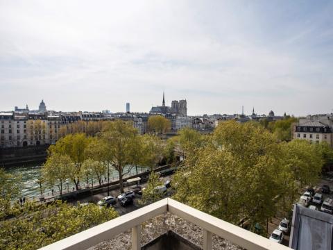 Útsýnið frá Kjarvalsstofu í París, horft yfir tré og ána.