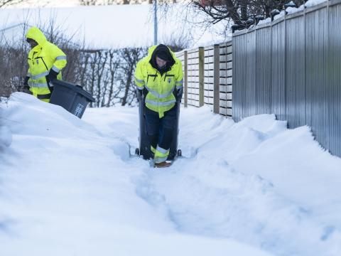 Starfsfólk sorphirðu að störfum í miklum snjó.