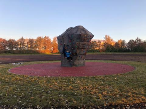 Tvö börn klifra á klifursteini á Klambratúni, sem varð til eftir kosningu í Hverfið mitt. Sumar.