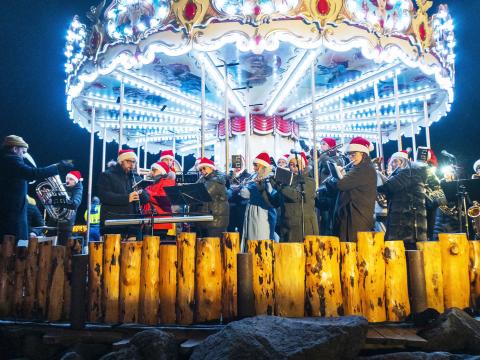The Workers' Brass Band plays in a brightly lit carousel in The Valley of Lights in Laugardalur, at the opening of Christmas Valley 2024.
