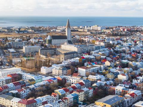 An aerial view of Reykjavík's city center shows Hallgrímskirkja church and the blue straits. 