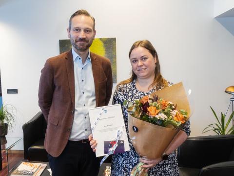 Einar Þorsteinsson and Marta Wieczorek, Reykjavík Resident of the Year 2024, pose in the mayor's office. Marta holds a bouquet and her certificate of recognition.