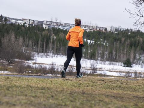 Woman running outdoors. Forest and snow.