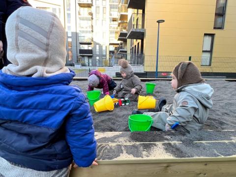 Börn að leika í sandkassa.