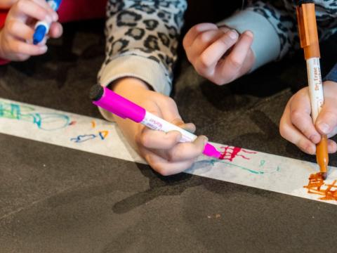 Börn að leik með marglita tússliti