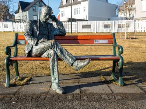 Tómas Guðmundsson sits on the bench by Tjörnin pond on a beautiful day 
