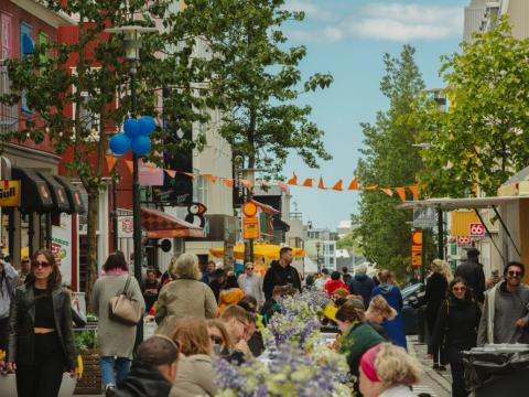 Crowd on Laugavegur street where a long table has been set up in the middle of the street