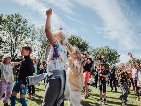 Children dancing enthusiastically in good weather at a summer festival in the Family Park.