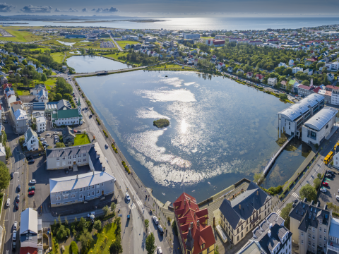 A view of Tjörnin pond and Reykjavík City Hall on a sunny day.