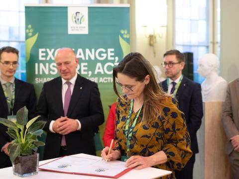 The signing ceremony. Attendees in the background.