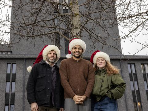 Mynd af þremur leikurum fyrir framan Þjóðleikhúsið