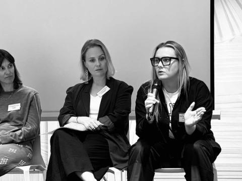 Svarthvít mynd af þremur konum sem sitja í pallborði og tala um heimilisleysi. 