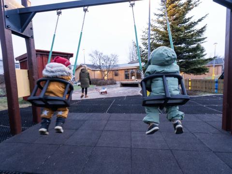 Leikskólabörn að róla.