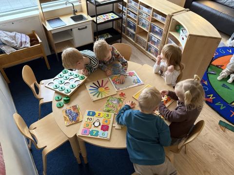 Mynd af leikskólabörnum skoða bækur.