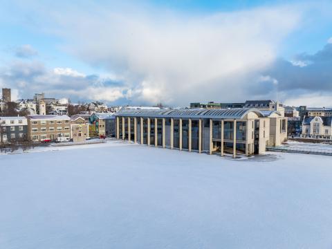 Ráðhúsið, loftmynd, tekin frá Fríkirkjuvegi sirka. Vetur, Tjörnin lögð ís og snjó, himininn blár en með skýjum.
