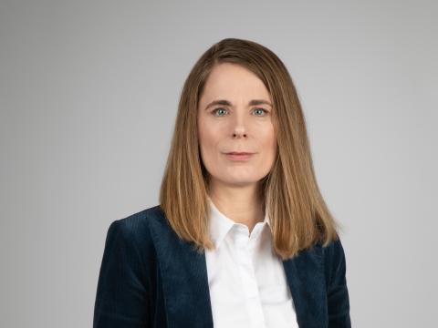 Ingunn Ólafsdóttir, internal auditor for Reykjavík City. Portrait photo, gray background.