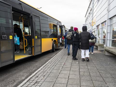 Fólk að labba inn í strætó fyrir utan Mjóddina