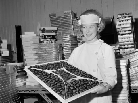 Image from the Nói candy factory tour, a female employee holding a box of chocolates.