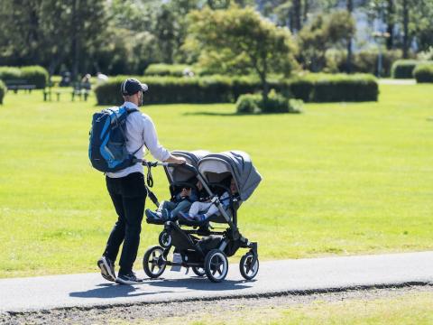 Manneskja á gangi með kerru.