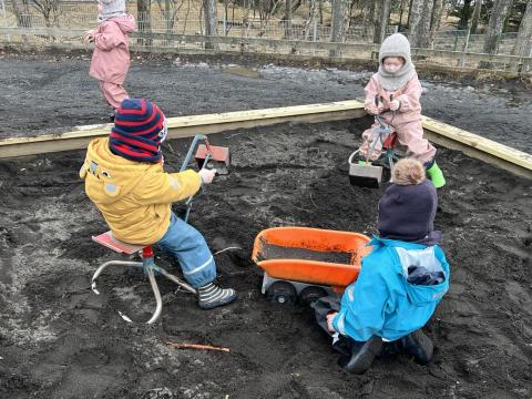 Börn að leik í sandkassa.