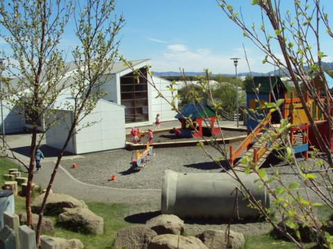 Sandkassi og leiktæki á lóð Rauðuborgar.