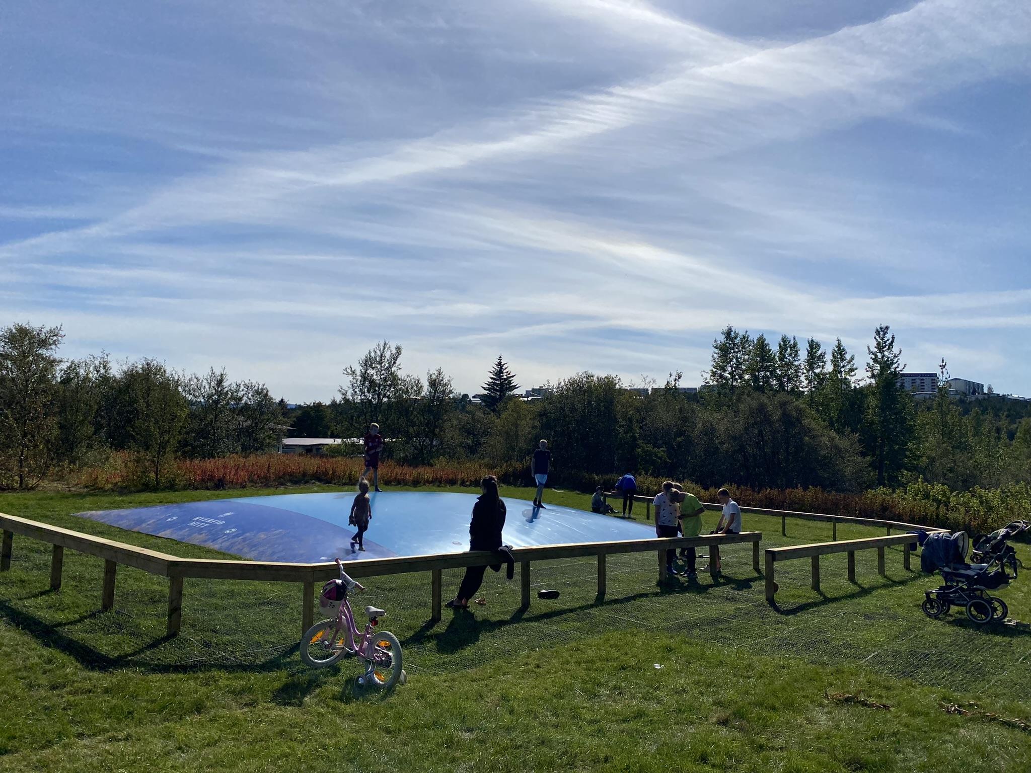 Hoppandi börn á ærslabelg í Árbæ.